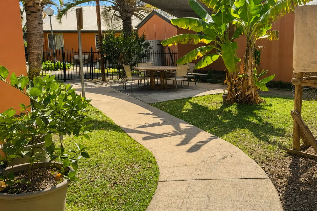 Garden pathway winding past banana palms at Christine Court